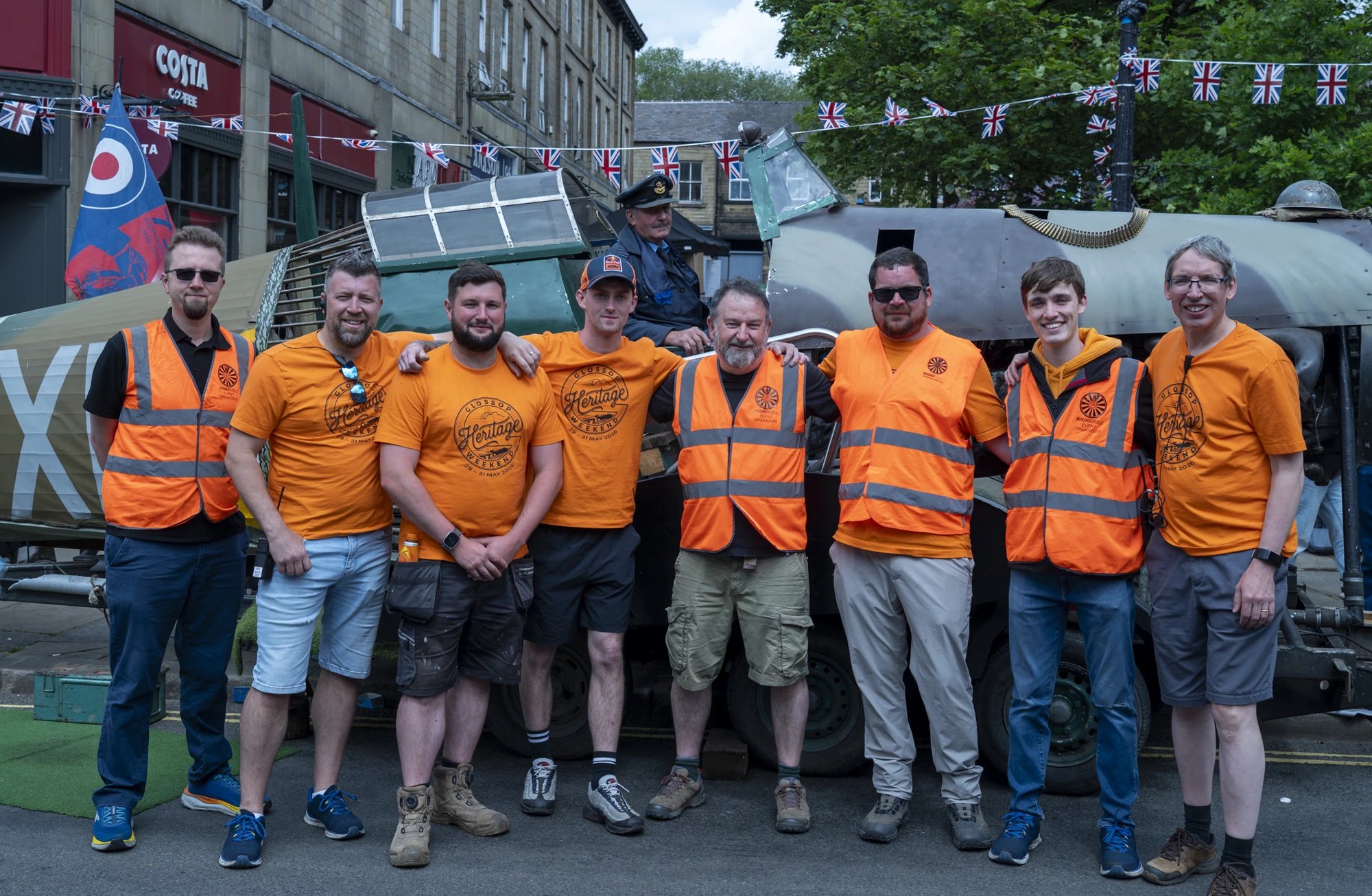 Round Table volunteers posing in front of a Spitfire display on Glossop high street during Heritage Weekend
